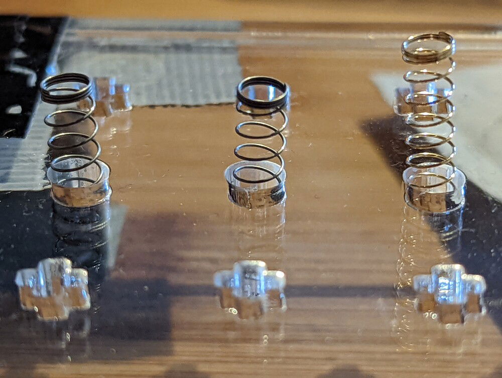 Stock springs on left, new gold one on right